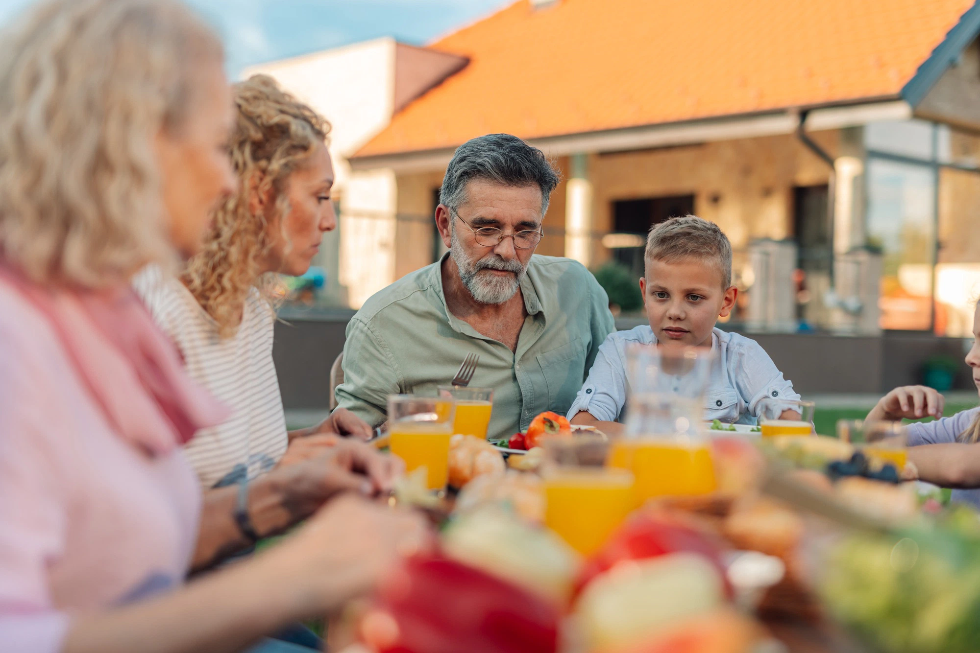 Family enjoying healthy lunch in backyard garden-malnutrition