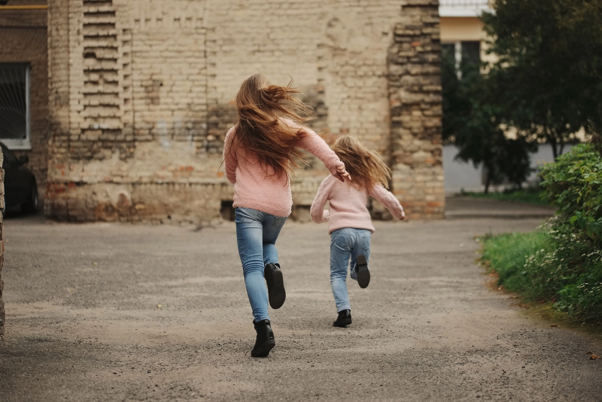 two girls with long hair running away-foster children