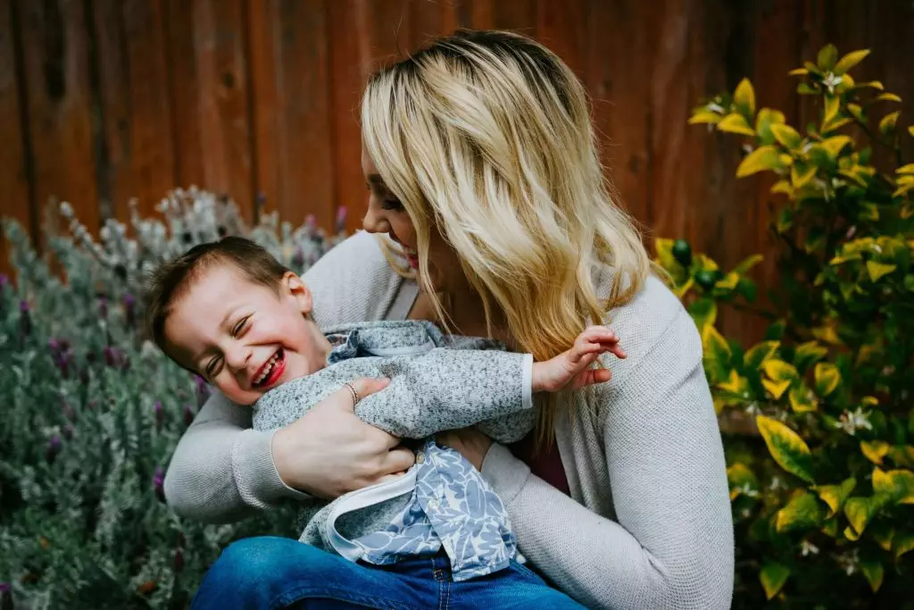 How to Protect Your Parental Rights in Massachusetts: A Comprehensive Guide 27 Attachment options… A woman wearing a white sweater carrying a daughter, representing the caring and supportive environment parents strive to provide.